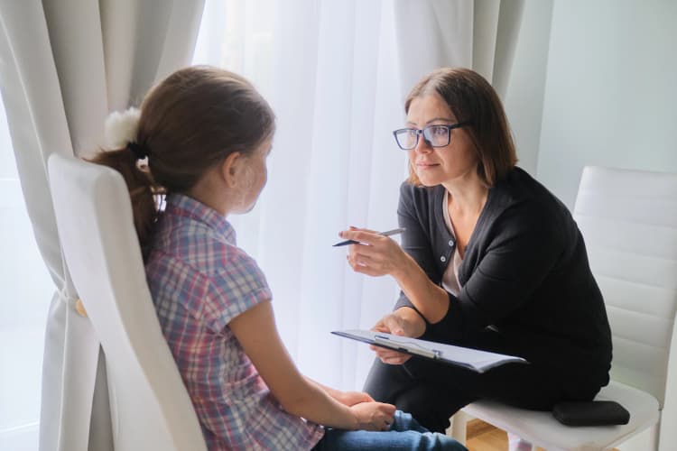 Woman Doctor talking to Girl Patient